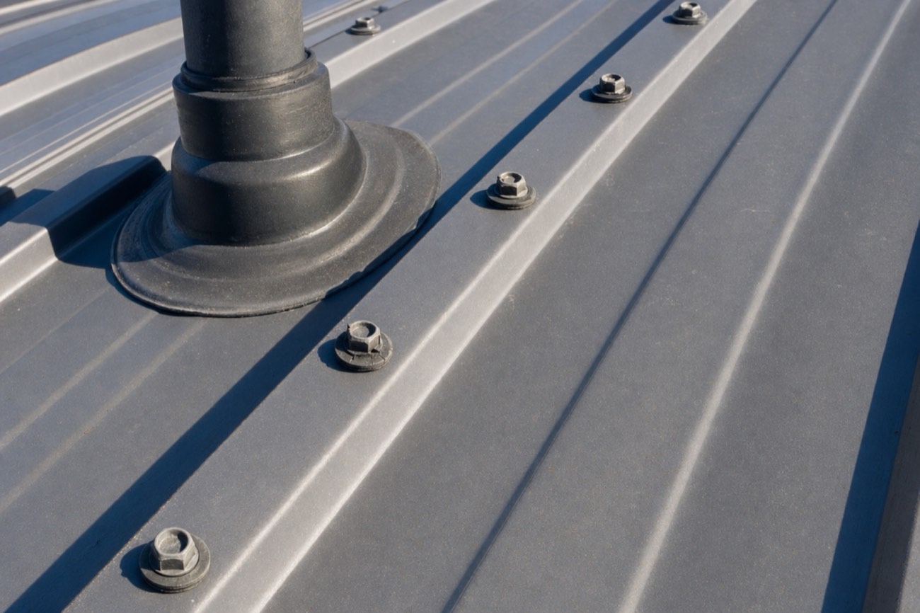 Rows of screws with rubber washers on an exposed-fastener metal roof