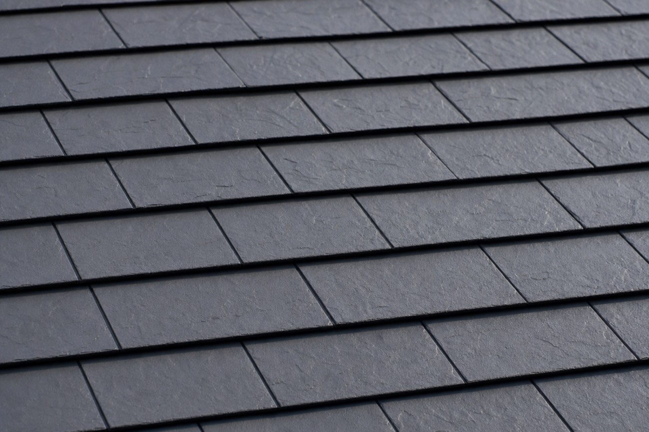 Close-up of stamped steel roof shingles with a slate texture